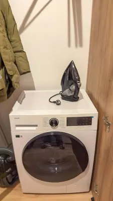 a black hat sitting on top of a washing machine at Central Breeze Flat x Self Check-in in Vilnius