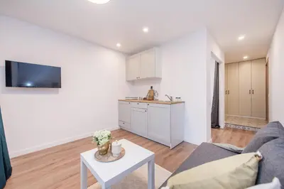 a kitchen and living room with a couch and a table at 00Near Gates of Dawn Cozy bright 1 bedr in Vilnius