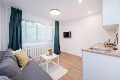 a living room with a couch and a kitchen at 00Near Gates of Dawn Cozy bright 1 bedr in Vilnius