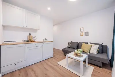 a kitchen and living room with a couch and a table at 00Near Gates of Dawn Cozy bright 1 bedr in Vilnius