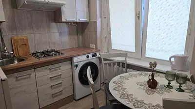 a small kitchen with a table and a stove at Kambarių nuoma Kaune Taikos pr in Kaunas