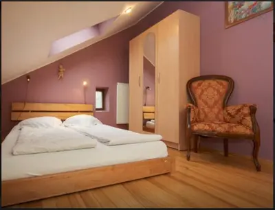 a bedroom with a bed and a chair at Apartamentai Vilnius Užupis in Vilnius