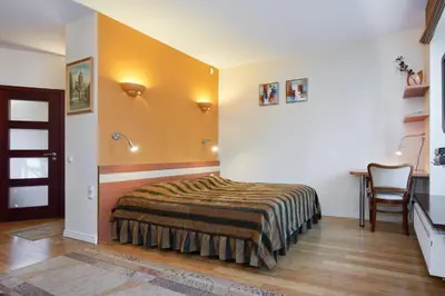 a bedroom with a bed and a desk in it at Apartamentai Vilnius Užupis in Vilnius