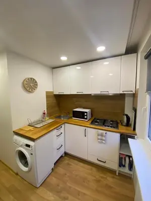 a kitchen with white cabinets and a stove and a microwave at Two Bedroom COZY apatment in Vilnius