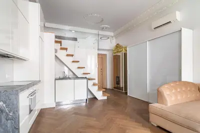 a living room with white walls and a staircase at Old Town Luxury apartment self check inn in Vilnius