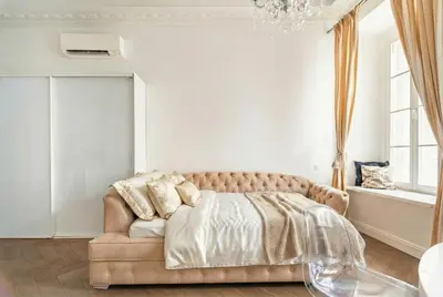 a bedroom with a couch and a chandelier at Old Town Luxury apartment self check inn in Vilnius