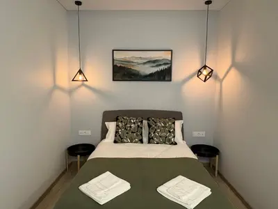 a bedroom with a bed and two lights on the wall at Studio 204 Vilnius Old Town in Vilnius