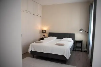 a bedroom with a large white bed with two pillows at Stylish & Brand New 1 BDR Apartment in Old Town in Vilnius