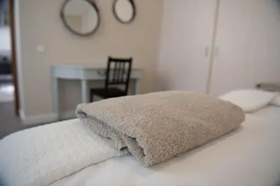 a pillow sitting on top of a bed with a table at Stylish & Brand New 1 BDR Apartment in Old Town in Vilnius