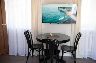 a black table with chairs and a television on a wall at Stylish & Brand New 1 BDR Apartment in Old Town in Vilnius