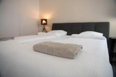 two white beds with a brown pillow on them at Stylish & Brand New 1 BDR Apartment in Old Town in Vilnius