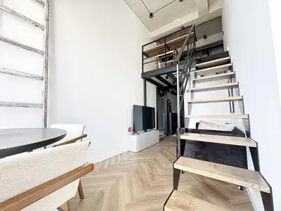 a room with a loft bed and a table at Rooftop Terrace Loft 15 Minute Walk to Zalgiris Arena in Kaunas