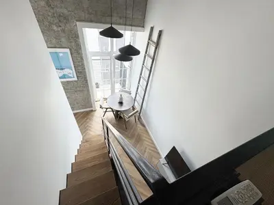 a staircase with a table and chairs in a room at Rooftop Terrace Loft 15 Minute Walk to Zalgiris Arena in Kaunas