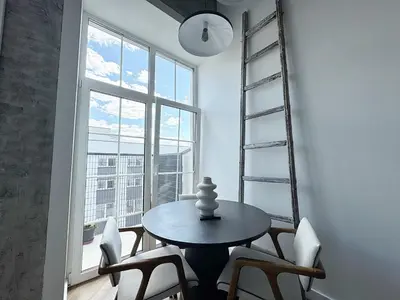 a table and chairs in a room with a window at Rooftop Terrace Loft 15 Minute Walk to Zalgiris Arena in Kaunas