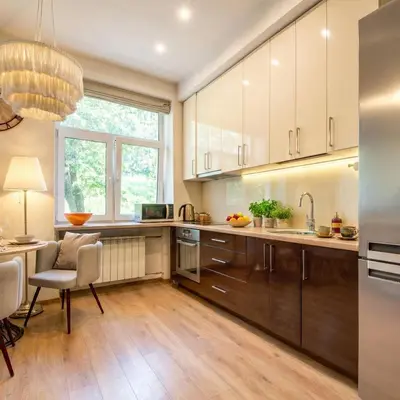 a kitchen with wooden cabinets and a table and chairs at Vilnius Central Apartment Free Parking in Vilnius