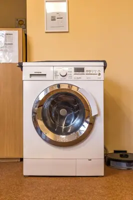 a white washing machine sitting next to a wall at Kaunas Center Hostel - Self-Check In in Kaunas