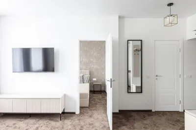 a room with white walls and a mirror at Varenastay in Varėna