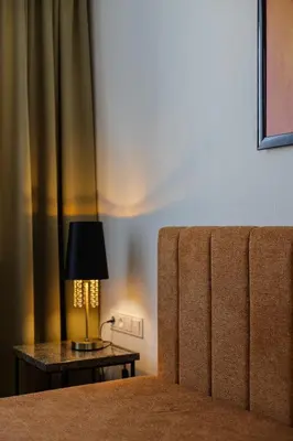 a bed with a lamp on a side table at Varenastay in Varėna