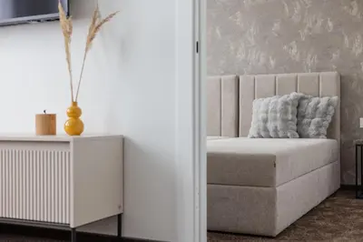 a room with a chair and a white cabinet at Varenastay in Varėna