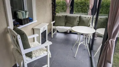 a small table and chairs in a room with a window at Vila Vynuogyne in Paberžė