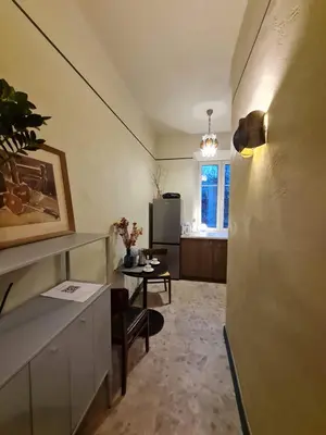 a living room with a table and a refrigerator at K15 History Apartments in Vilnius