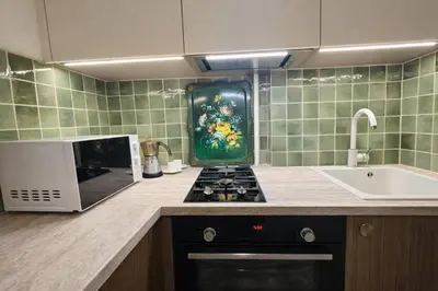 a kitchen with a stove top oven next to a microwave at K15 History Apartments in Vilnius