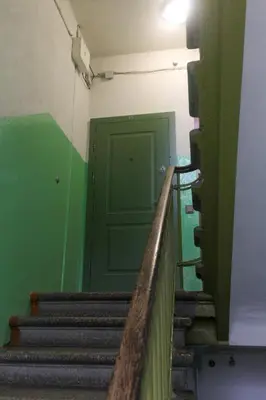 a staircase with a green door and a green wall at K15 History Apartments in Vilnius