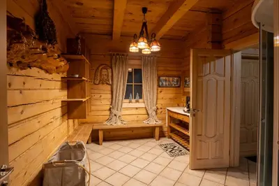 a kitchen in a log cabin with a chandelier at Močiutės sodyba in Latežeris