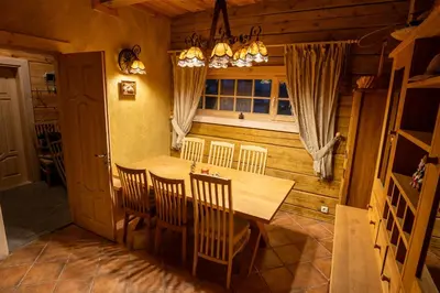 a dining room with a wooden table and chairs at Močiutės sodyba in Latežeris