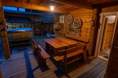 a porch of a cabin with a wooden table and bench at Močiutės sodyba in Latežeris