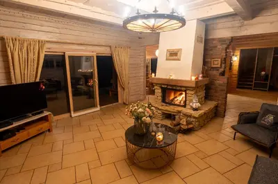 a living room with a fireplace and a television at Močiutės sodyba in Latežeris