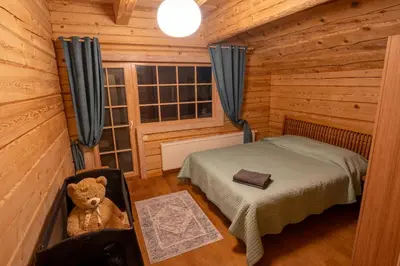 a small bedroom with a teddy bear in a cabin at Močiutės sodyba in Latežeris
