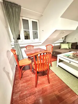 a dining room with a table and chairs and a couch at Old Town Attic Ignoto 16 SELF CHECK IN in Vilnius