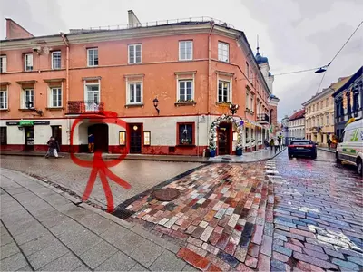 a red person walking down a street with buildings at Old Town Attic Ignoto 16 SELF CHECK IN in Vilnius