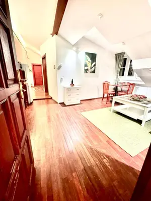 a living room with wooden floors and a table at Old Town Attic Ignoto 16 SELF CHECK IN in Vilnius