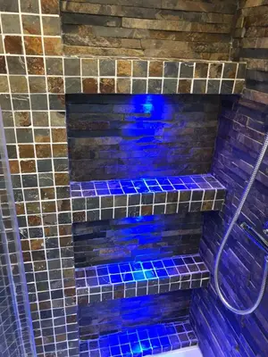 a bathroom with blue glass tiles on the wall at B-happy Apartments in Vilnius