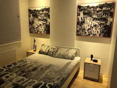 a bedroom with a bed with posters on the wall at B-happy Apartments in Vilnius