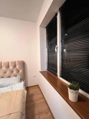 a bedroom with a bed and a window with black blinds at Mėja stay in Kaunas