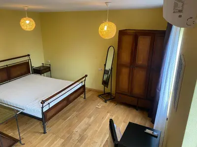 a bedroom with a bed and a dresser and lights at Gudyno in Kaunas