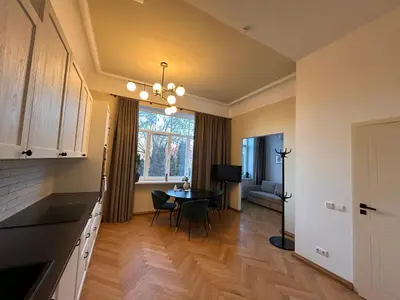 a kitchen and dining room with a table and a window at Vydūno apartamentai 10 in Kaunas