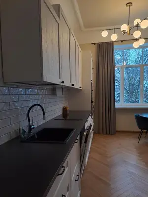 a kitchen with black counter tops and a sink at Vydūno apartamentai 10 in Kaunas
