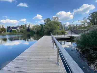 a wooden bridge over a body of water at New luxury modern Apartment in Šnipiškės in Vilnius