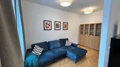 a living room with a blue couch in a room at Vydūno apartamentai 8 in Kaunas