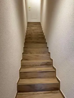 a staircase with wooden floors and a white door at Ajeru Apartments in Kaunas