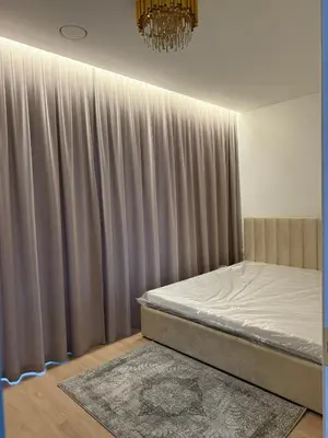 a bed in a room with a curtain at Ajeru Apartments in Kaunas