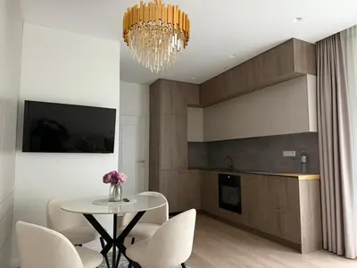 a kitchen with a table and chairs and a chandelier at Ajeru Apartments in Kaunas