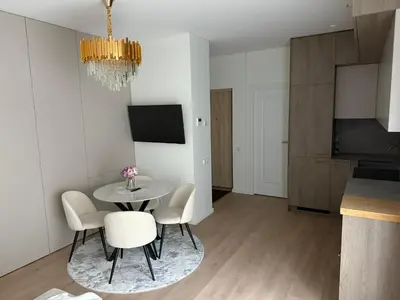 a kitchen and dining room with a table and chairs at Ajeru Apartments in Kaunas