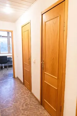 a hallway with two wooden doors in a room at Vilnius Old Town Riverside Apartment in Vilnius