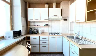 a kitchen with white cabinets and a sink at Vilnius Old Town Riverside Apartment in Vilnius