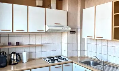 a kitchen with white cabinets and a stove top oven at Vilnius Old Town Riverside Apartment in Vilnius